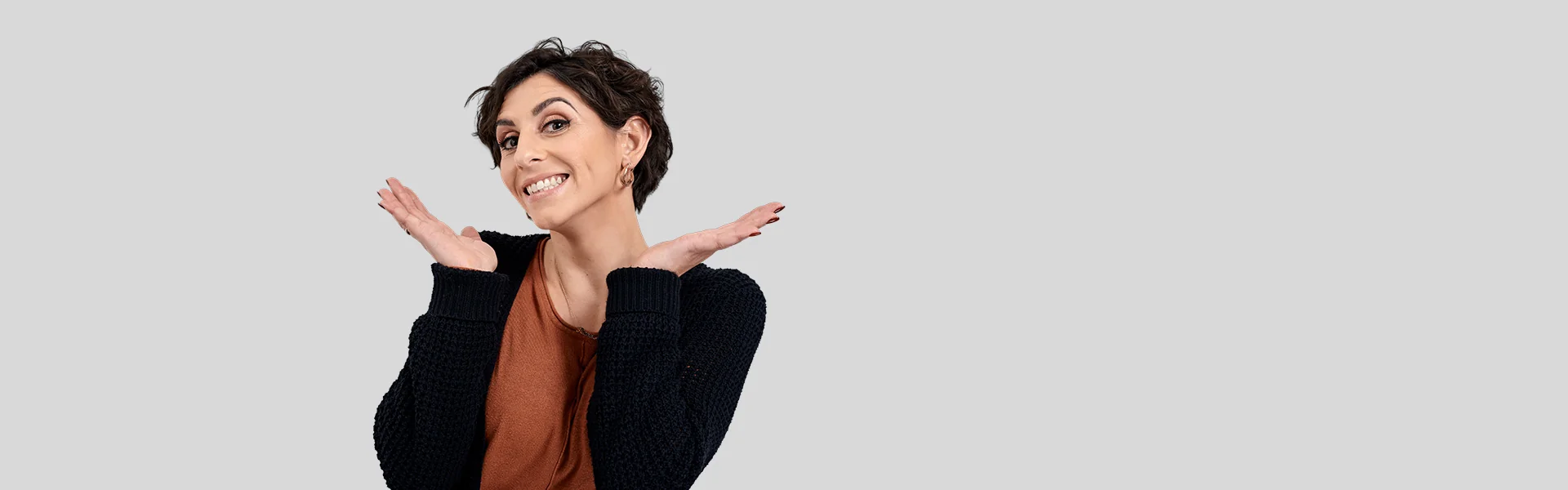 Frau mit kurzen Haaren lacht, Hände neben dem Gesicht
